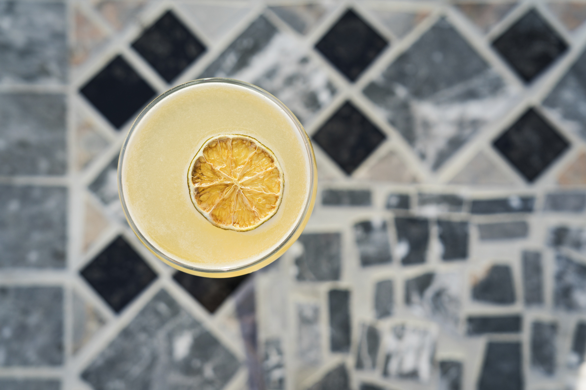 Overhead view of a golden cocktail with a dried citrus wheel