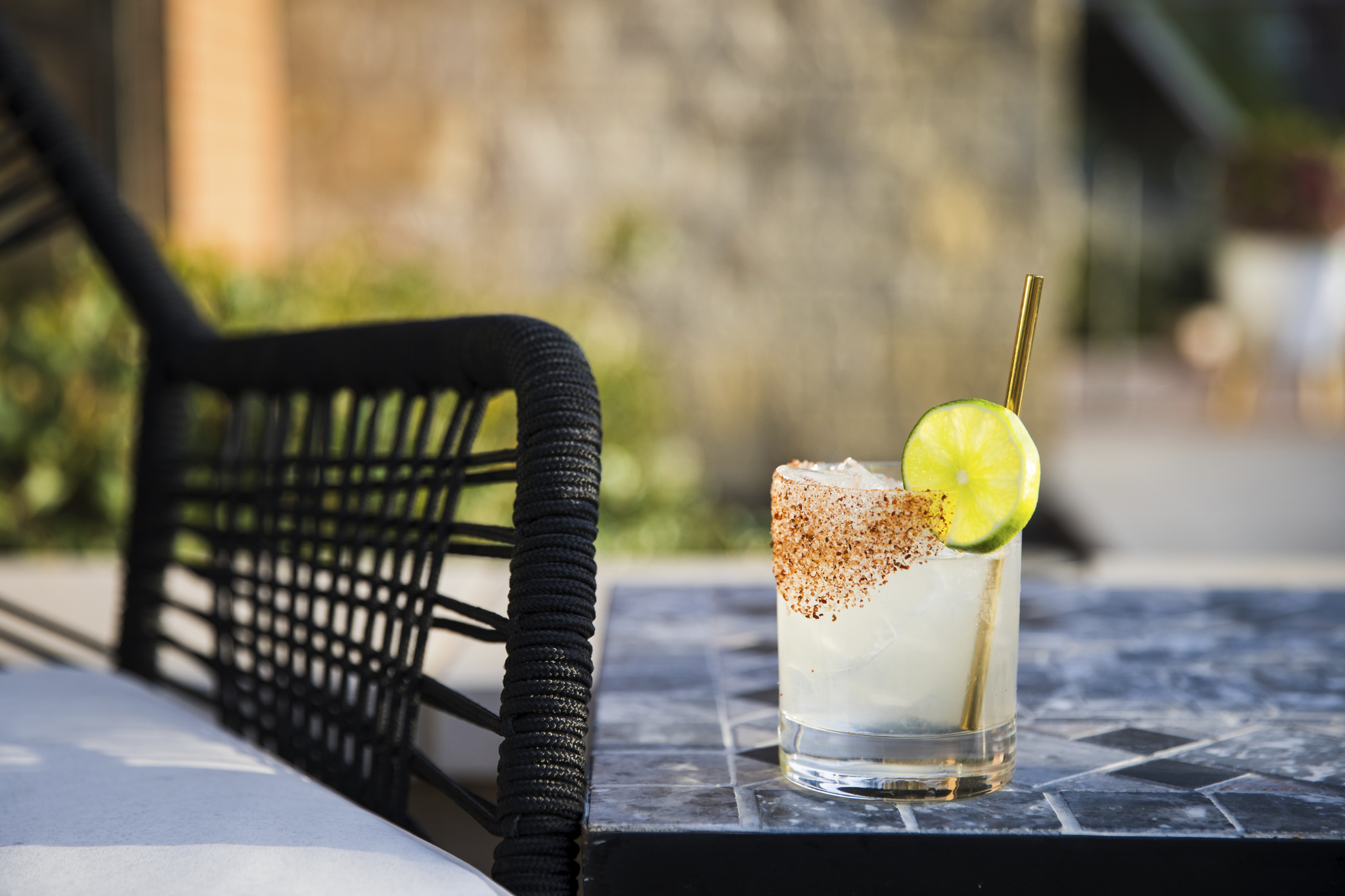 Citrus cocktail with a spiced rim on an outdoor table