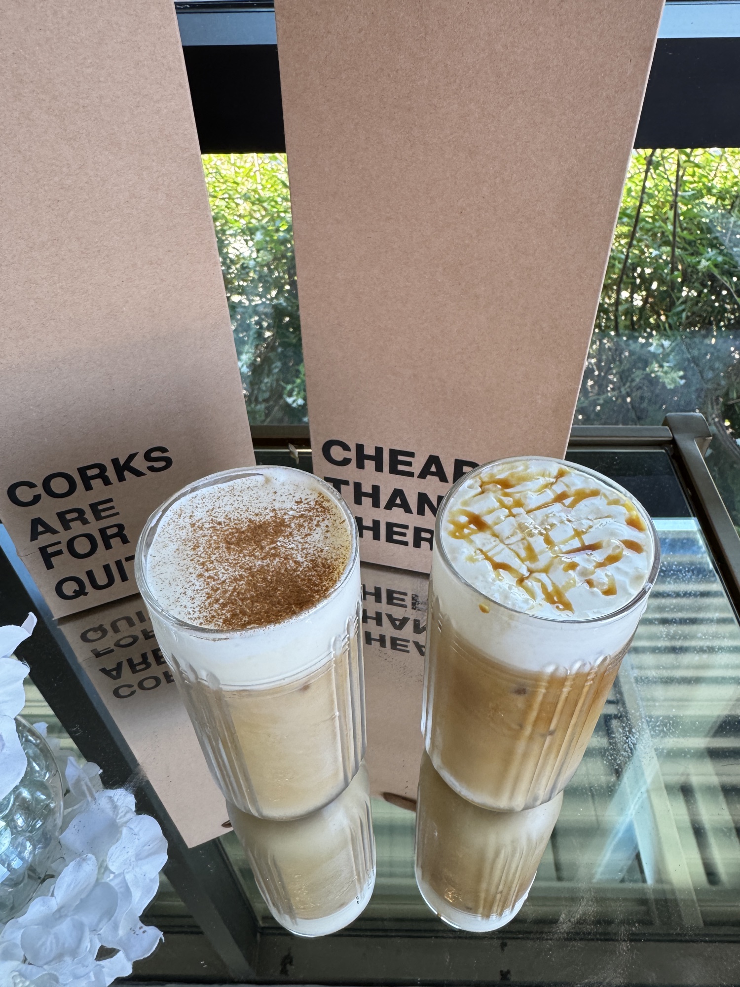 Iced caramel and cinnamon lattes beside Locals menus in the front window