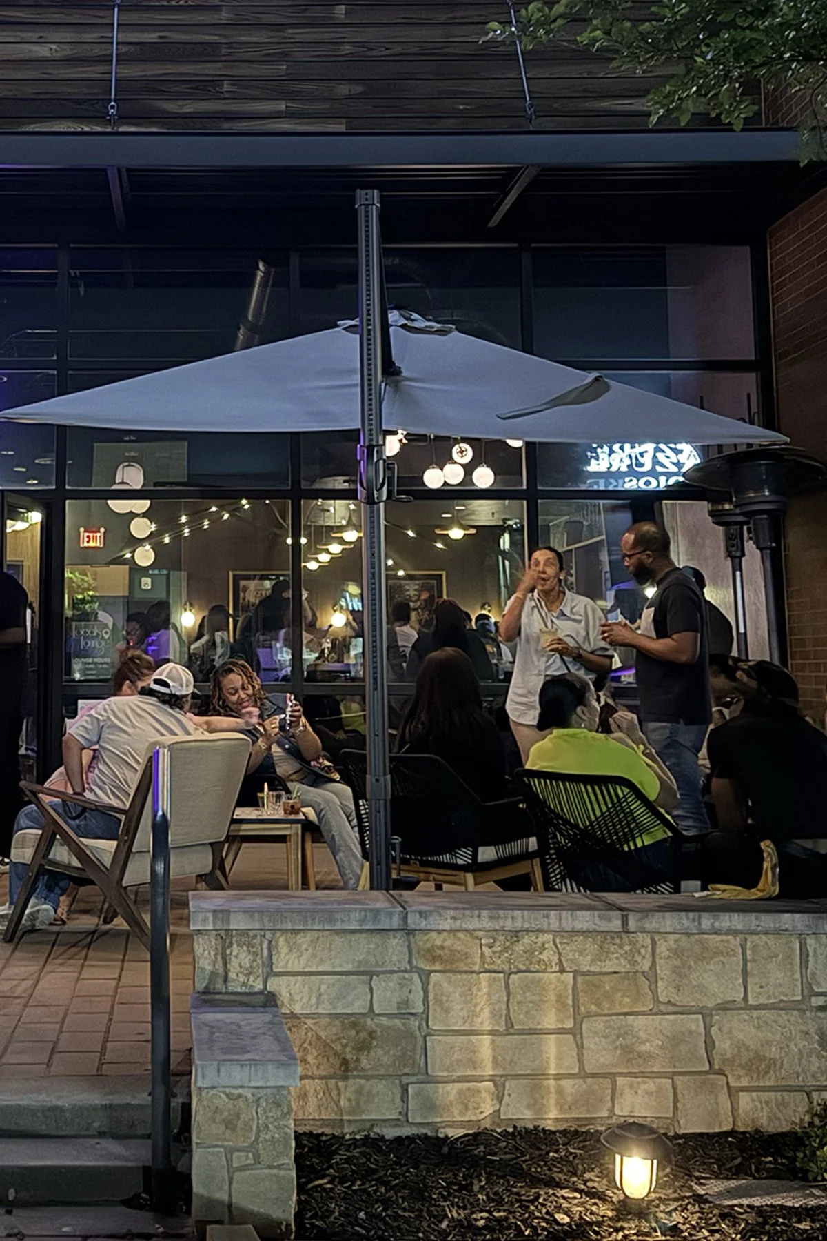 Guests gathering on the Locals Lounge patio in the evening