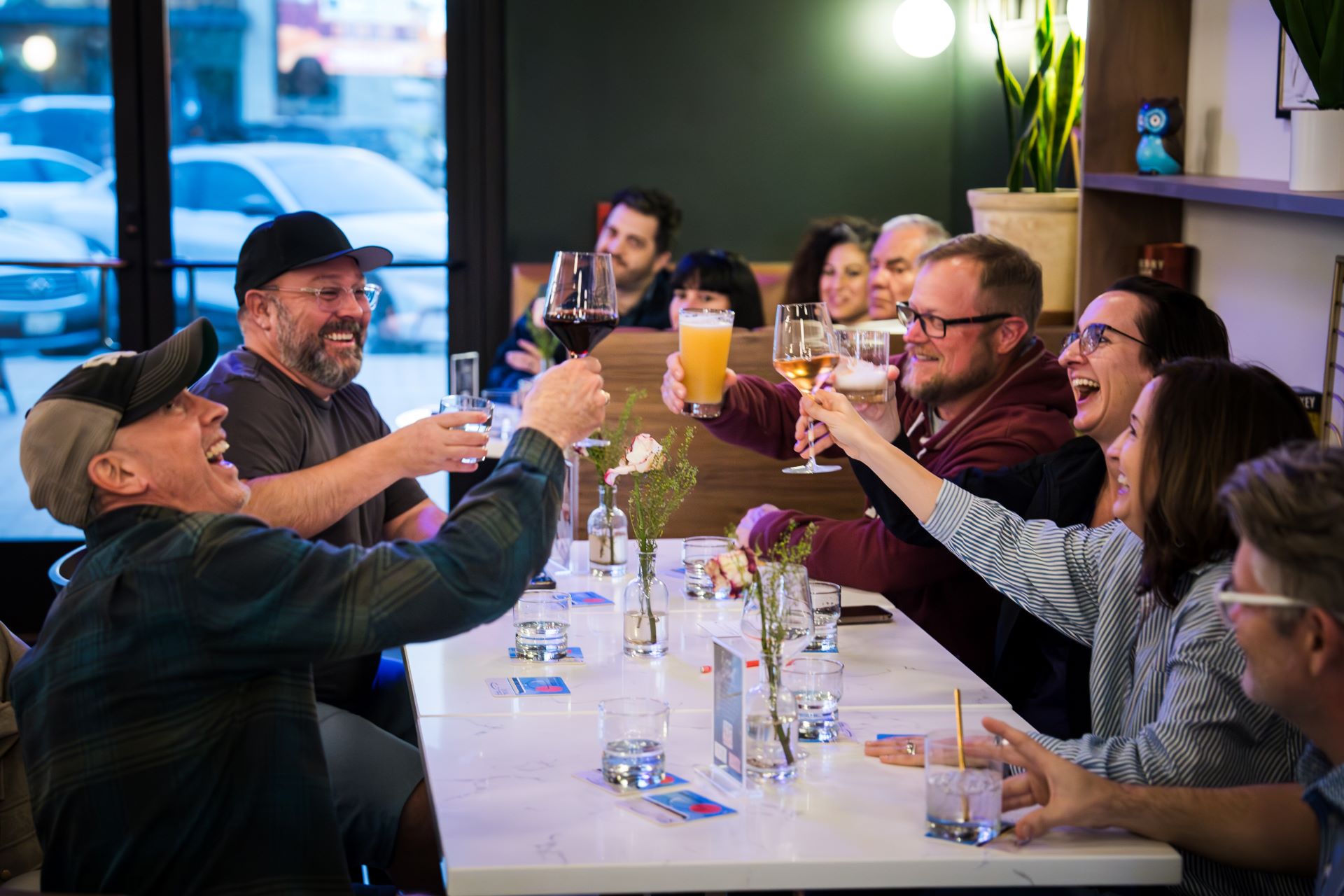 Friends raising cocktails together inside Locals Lounge